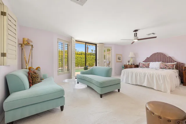 a spacious bedroom with a bed and a flat screen tv