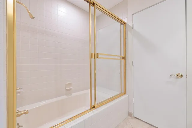 a bedroom with a large bed wooden floor and windows