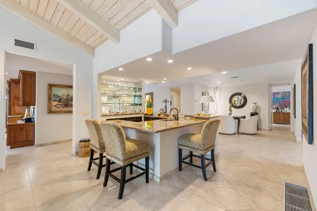 a dining hall with stainless steel appliances lots of white furniture a dining table and chairs with wooden floor