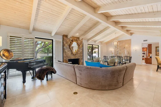 a living room with fireplace furniture and a large window
