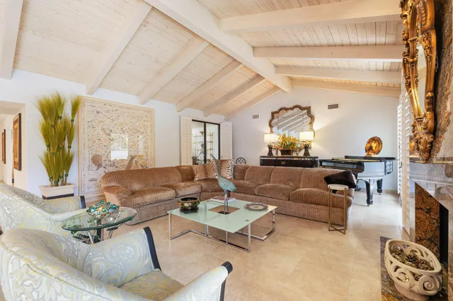 a living room with furniture a fireplace and a dining table with wooden floor