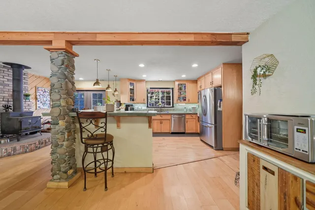 a kitchen with stainless steel appliances kitchen island granite countertop a table and chairs in it