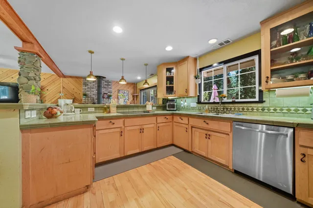 a kitchen with stainless steel appliances granite countertop a sink and wooden cabinets