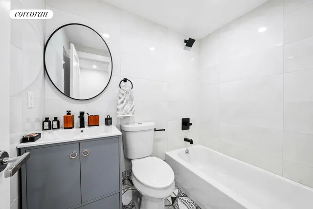 a living room with furniture white walls and a dining table with kitchen view