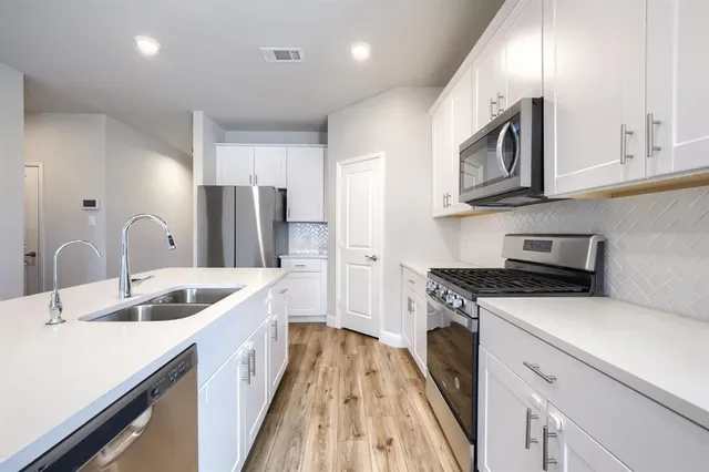 a kitchen with stainless steel appliances granite countertop a sink stove and refrigerator