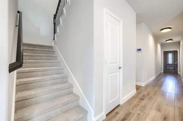 a view of a hallway with wooden floor and entryway