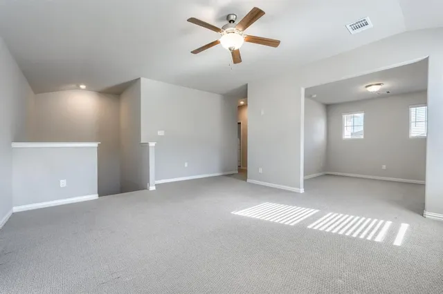 a view of a big room with a ceiling fan and a window