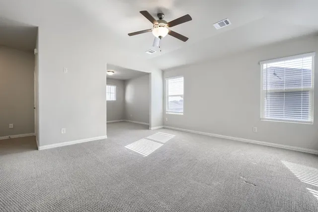 an empty room with fan and windows