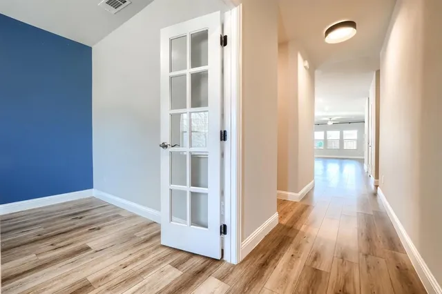 a view of a hallway with wooden floor and staircase