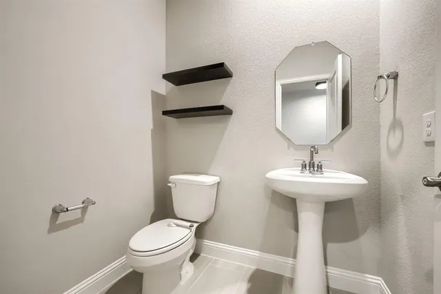 a bathroom with a toilet sink and mirror
