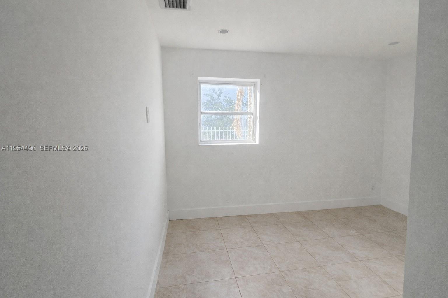 2217 Southwest 11th Street Miami, FL 33135 - Photo 6 of 13 an empty room with a window