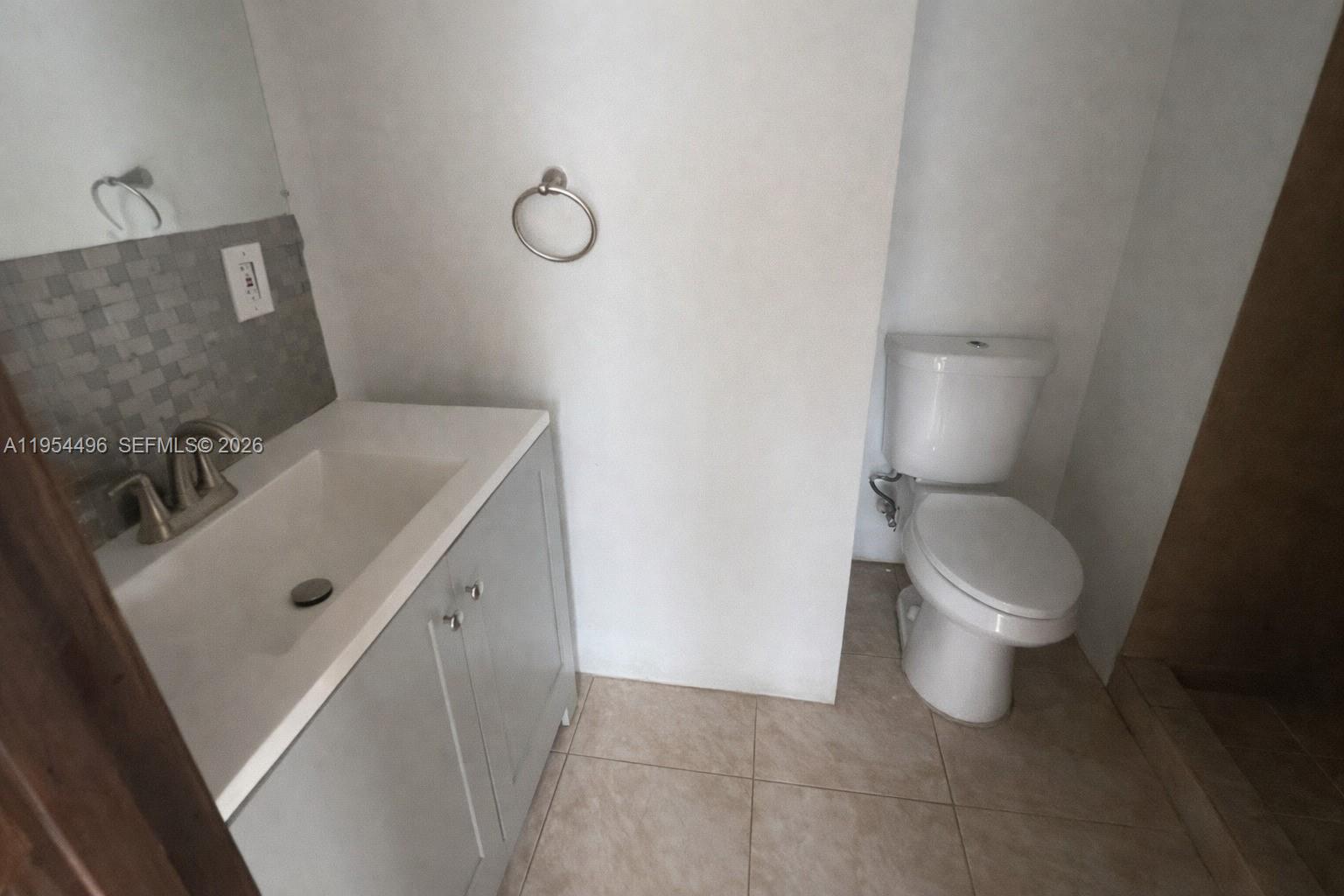 2217 Southwest 11th Street Miami, FL 33135 - Photo 9 of 13 a bathroom with a sink a toilet and a mirror