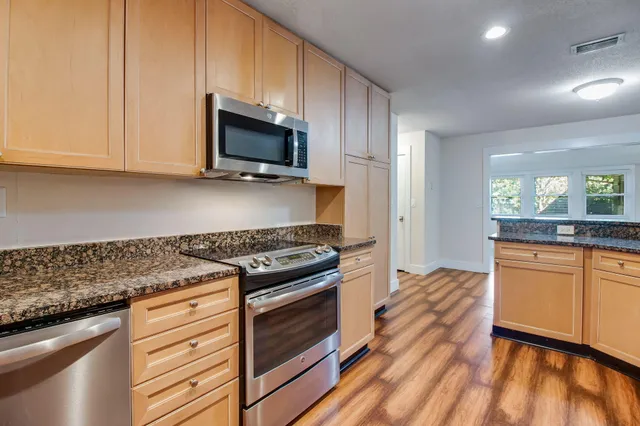 a kitchen with stainless steel appliances granite countertop a stove and a microwave
