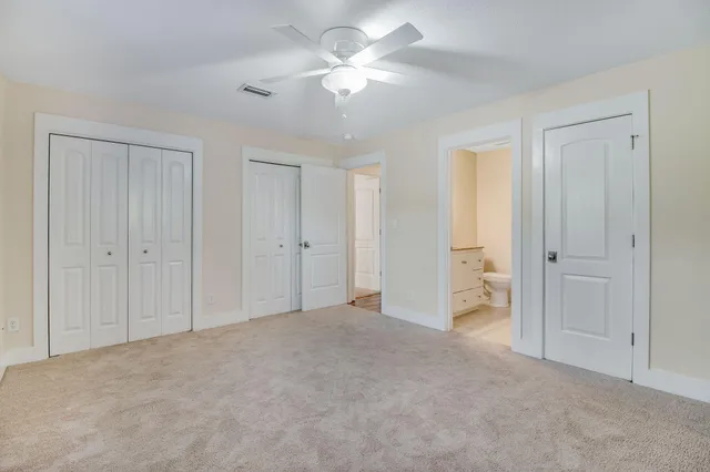 a view of a big room with closet and a chandelier fan