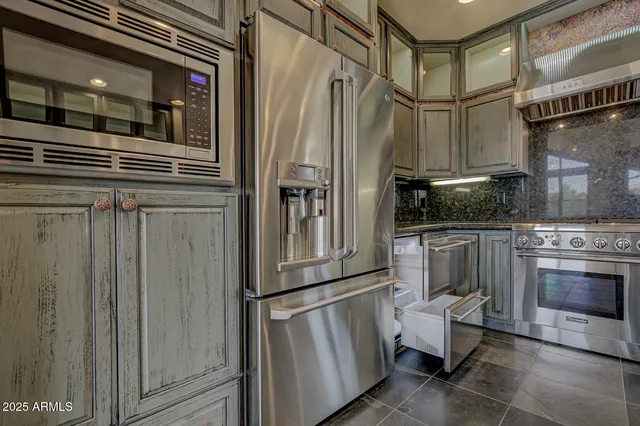 a kitchen with stainless steel appliances granite countertop a refrigerator and a stove
