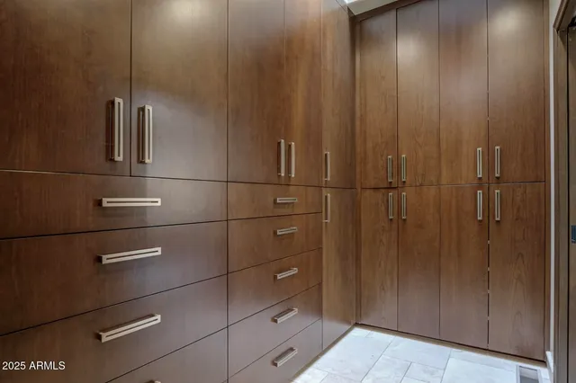 an empty room with closet and a chandelier fan