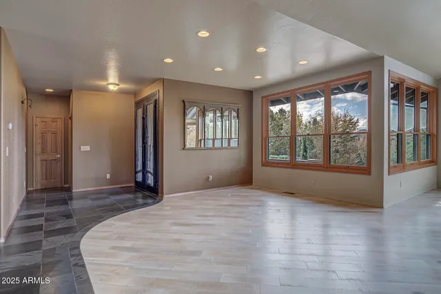 a living room with furniture large window and flat screen tv