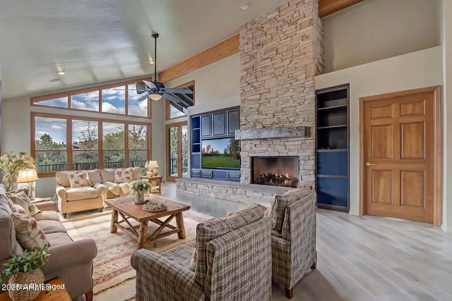 a view of a livingroom with furniture wooden floor ceiling fan and window