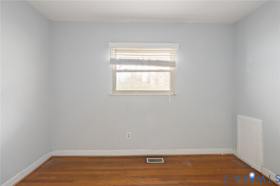 3109 North Parham Road, Unit 17 Henrico, VA 23294 - Photo 17 of 22 a view of an empty room with wooden floor and a window