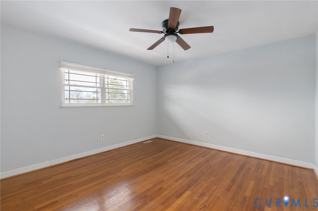 3109 North Parham Road, Unit 17 Henrico, VA 23294 - Photo 19 of 22 an empty room with wooden floor ceiling fan and windows
