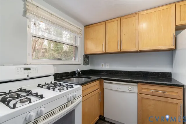 a kitchen with a stove a sink and a white cabinets