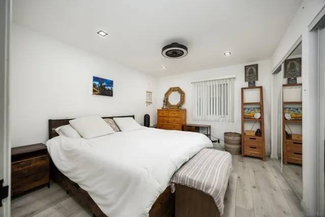 a bedroom with a bed and a refrigerator