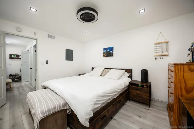 a bedroom with a bed and a computer on the desk