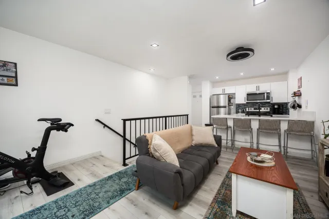 a living room with furniture and a view of kitchen