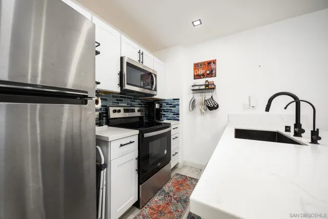 a kitchen with stainless steel appliances a refrigerator sink and microwave