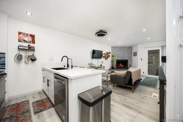a living room with furniture a flat screen tv and a sink