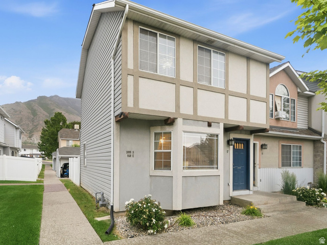 1099 South 950 East, Unit 17 Provo, UT 84606 - Photo 2 of 23 Townhome exterior featuring gray siding, a prominent blue front door with glass inserts, and a bay window on the lower level
