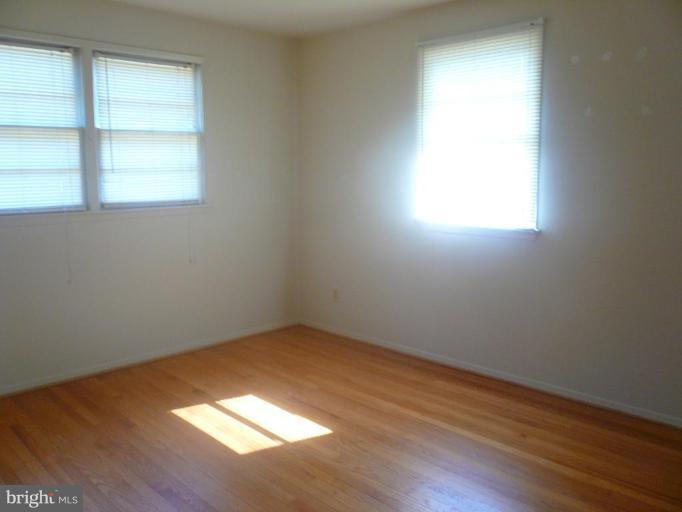 5944 Atteentee Road Springfield, VA 22150 - Photo 4 of 7 an empty room with wooden floor and windows