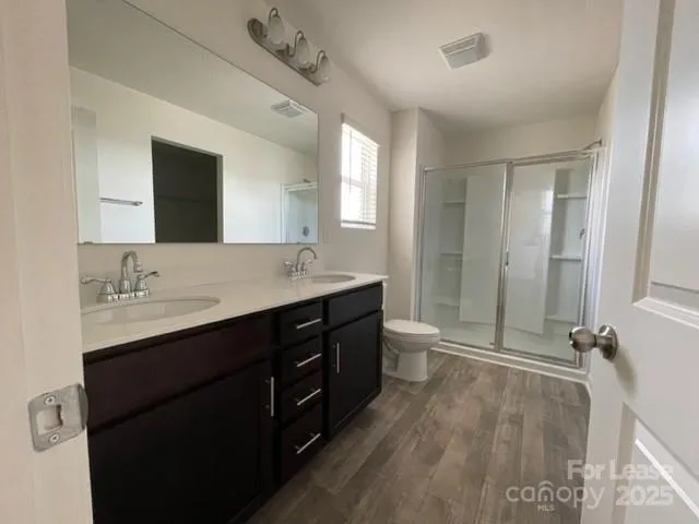 a bathroom with a double vanity sink a toilet and mirror