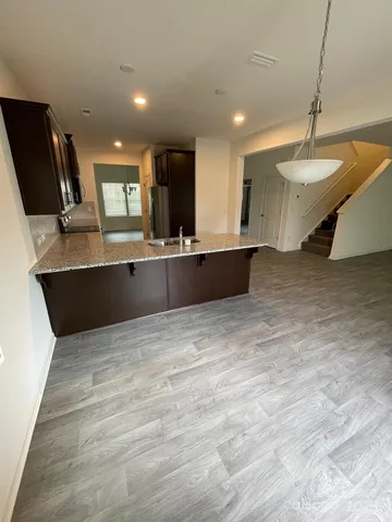 a large kitchen with kitchen island a sink stainless steel appliances and a fireplace