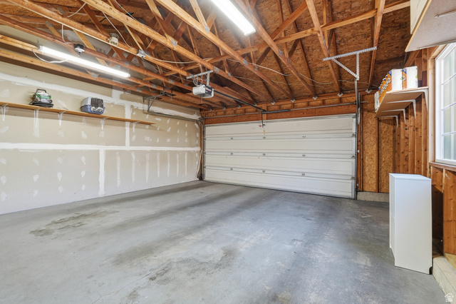 99 Penhurst Place Logan, UT 84341 - Photo 25 of 34 Spacious two-car garage with a concrete floor and exposed wood beam ceiling