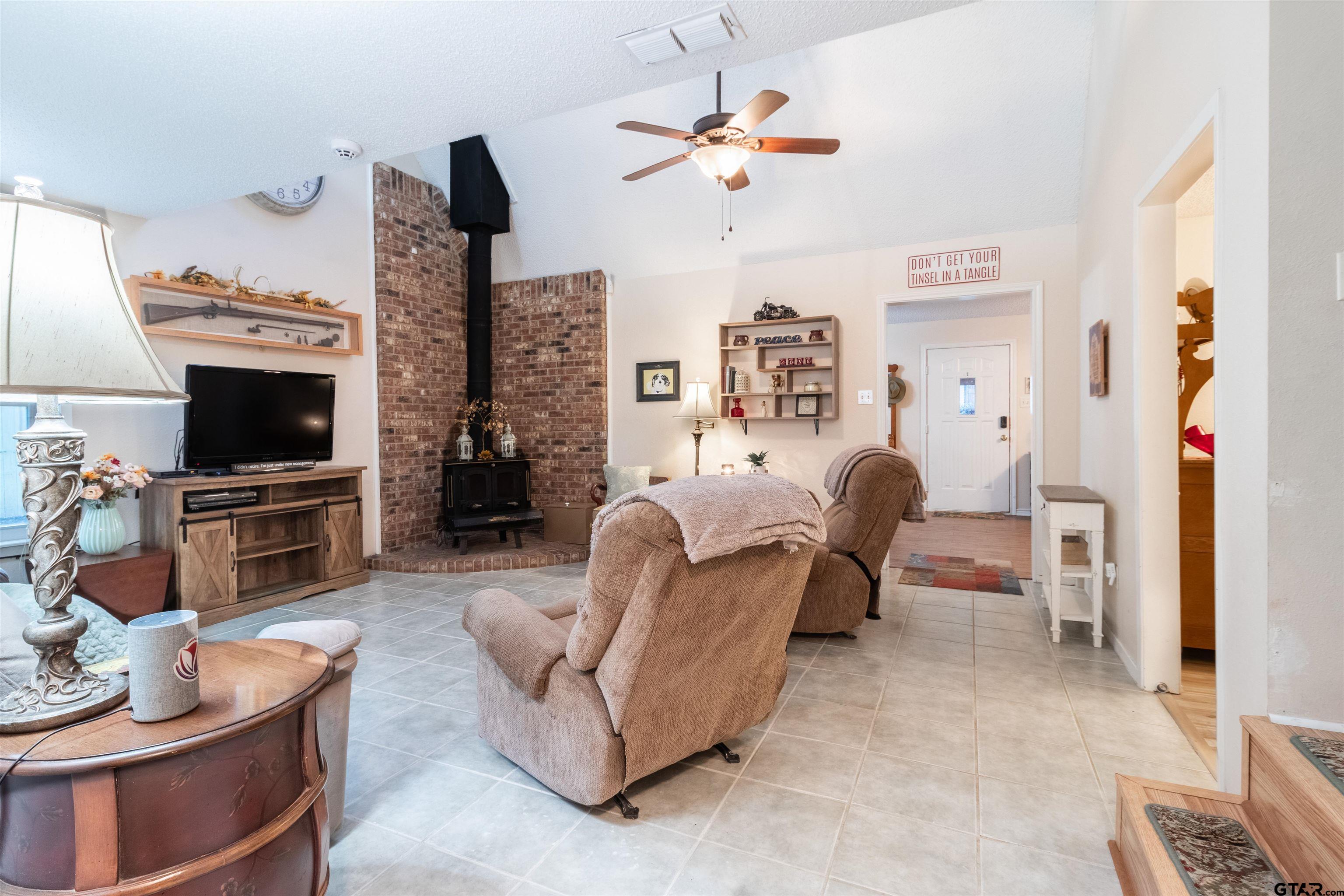 18219 Eastside Road Troup, TX 75789 - Photo 17 of 48 a living room with furniture a fireplace and a flat screen tv