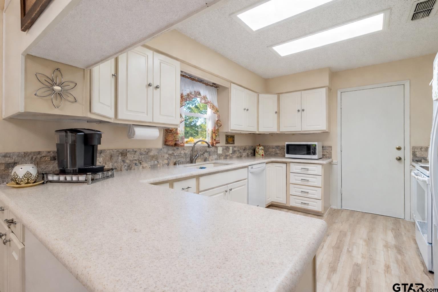 18219 Eastside Road Troup, TX 75789 - Photo 19 of 48 a kitchen with granite countertop a sink stove and refrigerator
