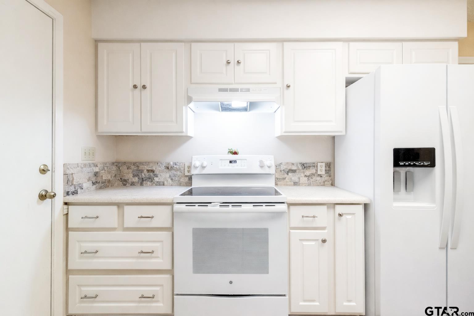 18219 Eastside Road Troup, TX 75789 - Photo 20 of 48 a kitchen with granite countertop white cabinets and white appliances