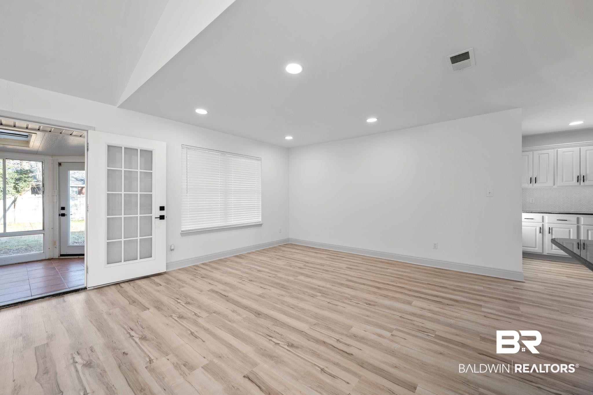 136 Destrehan Road Fairhope, AL 36532 - Photo 10 of 44 Unfurnished living room featuring light hardwood / wood-style floors, vaulted ceiling, and french doors