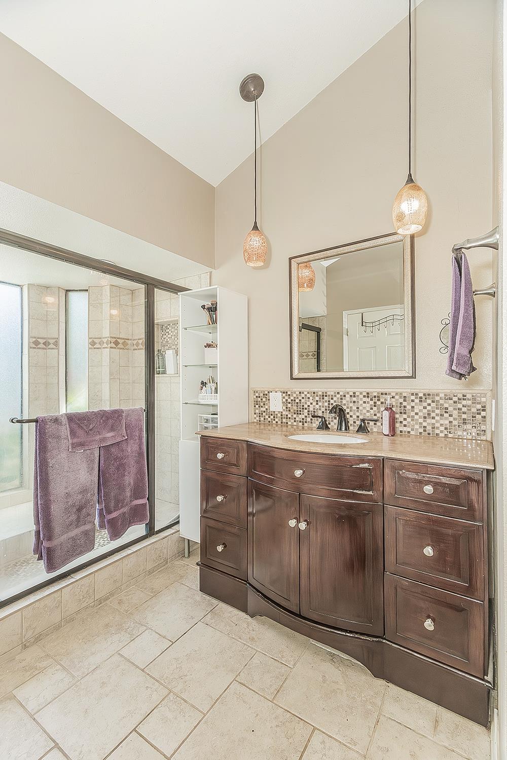 1908 East Niles Avenue Fresno, CA 93720 - Photo 17 of 30 a spacious bathroom with a granite countertop sink a mirror and shower