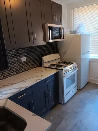 a kitchen with stainless steel appliances a stove microwave and sink