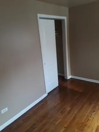 a view of a small space with wooden floor and a window