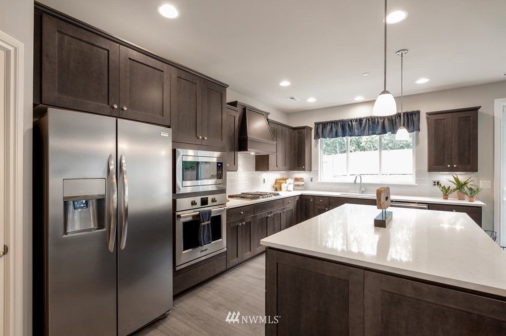 6328 Southeast 5th Place, Unit 5 Renton, WA 98059 - Photo 8 of 25 a kitchen with stainless steel appliances granite countertop a sink a stove and refrigerator