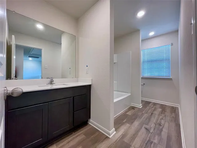 a bathroom with a sink a mirror and a bathtub