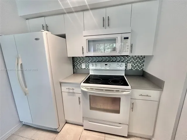 a white stove top oven sitting inside of a kitchen