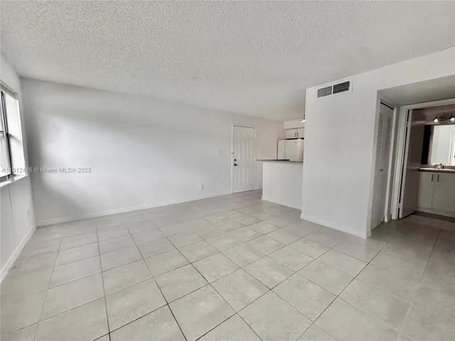a kitchen with kitchen island a sink a stove and white cabinets