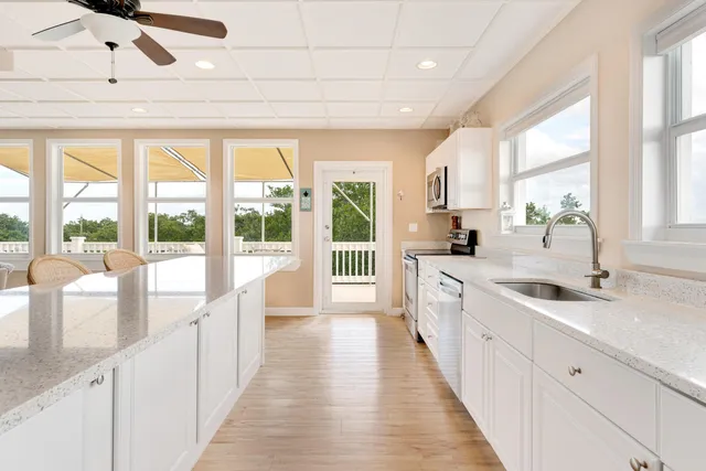 a large white kitchen with a large window