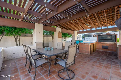 a view of a patio with table and chairs with wooden floor and fence
