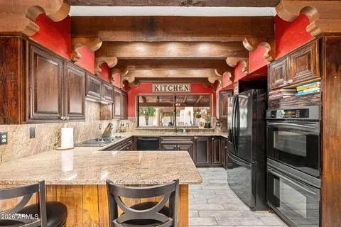 a kitchen with stainless steel appliances granite countertop a stove a sink and a refrigerator