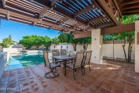 a view of a patio with table and chairs next to a yard